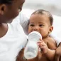 Mother giving milk in bottle to baby