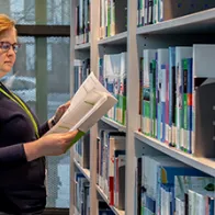 Woman in a library looking at a report