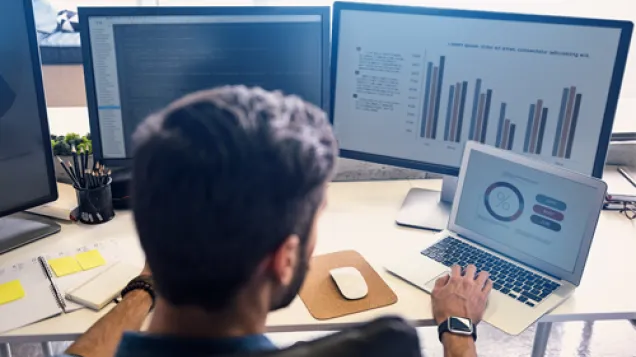 Man looking at data on screens