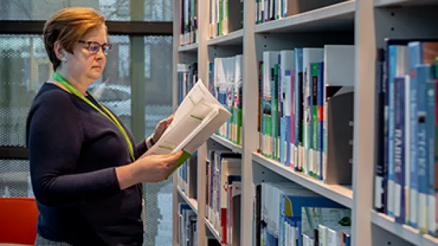 Woman in a library looking at a report