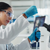 Laboratory worker in front of screens