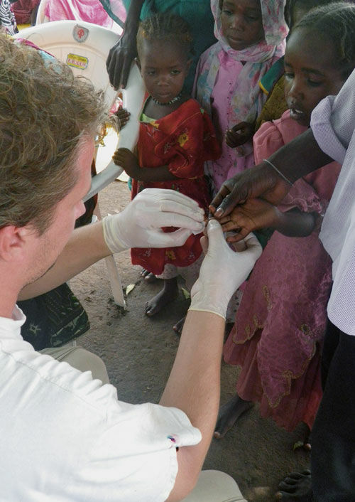 EPIET Postcard from the field -An epidemiologist taking a blood sample from a child for malaria testing, during Emergency response mission to fight malaria in Chad