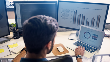 Man looking at data on screens