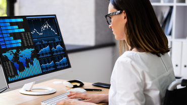 Female doctor typing and looking at data on screen