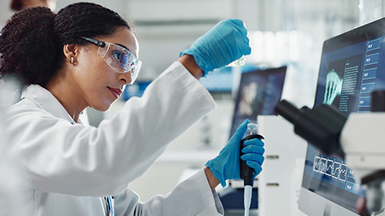 Laboratory worker in front of screens